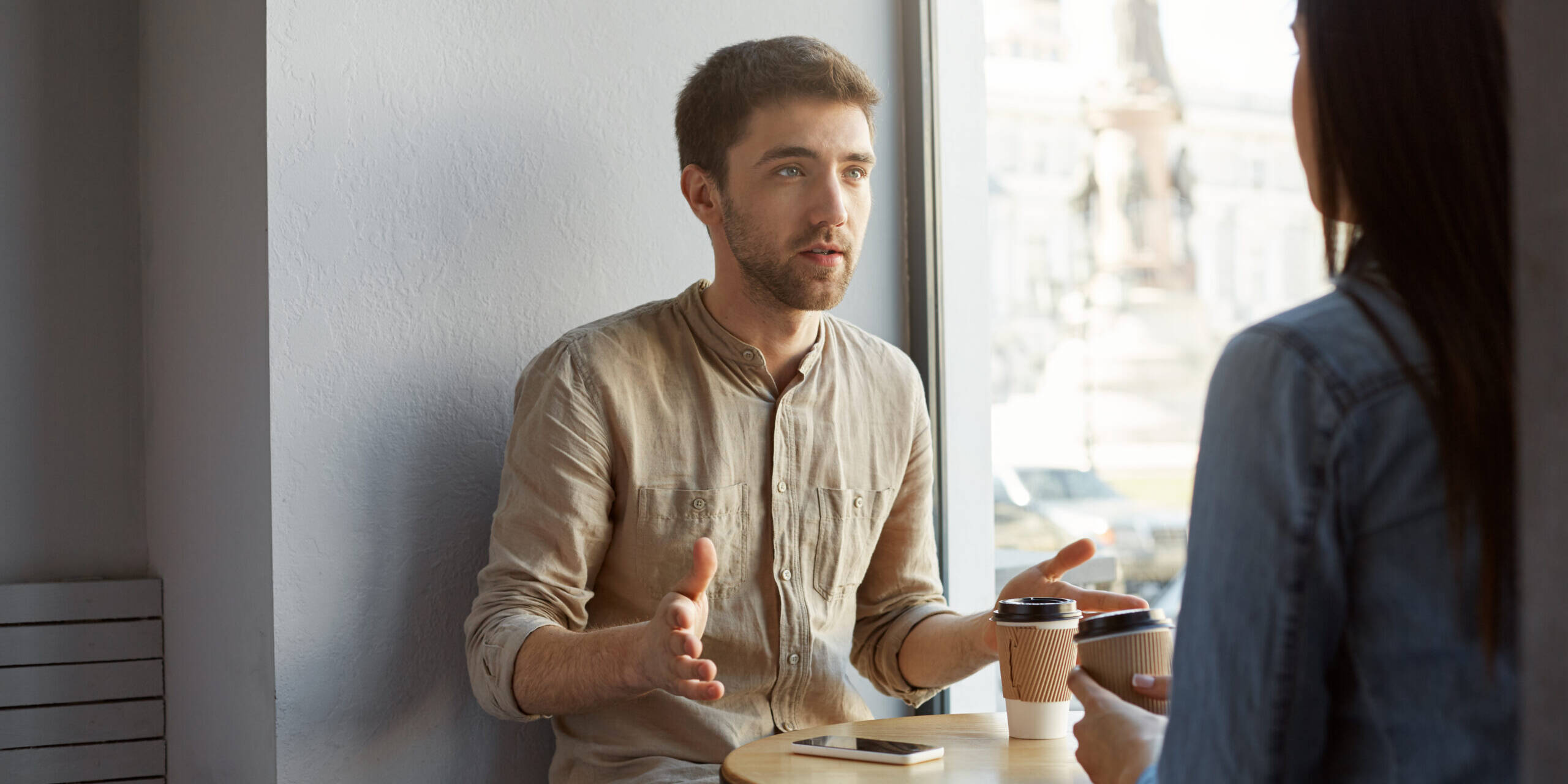 caucasian guy drinking coffee and talking