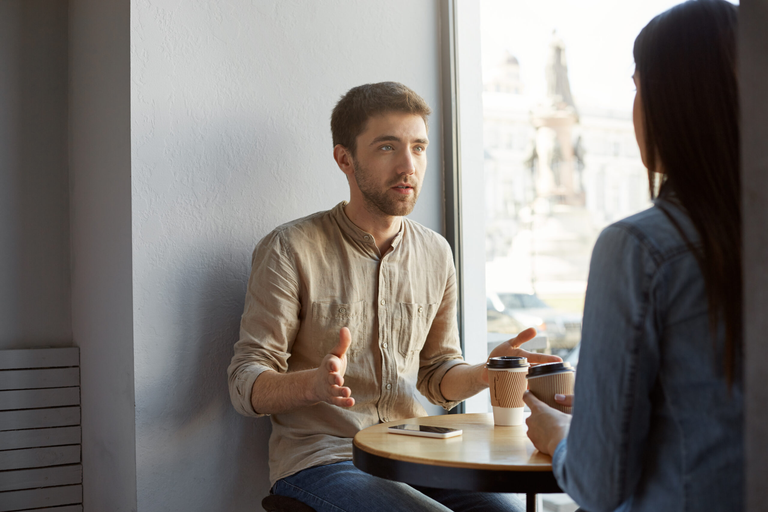 caucasian guy drinking coffee and talking